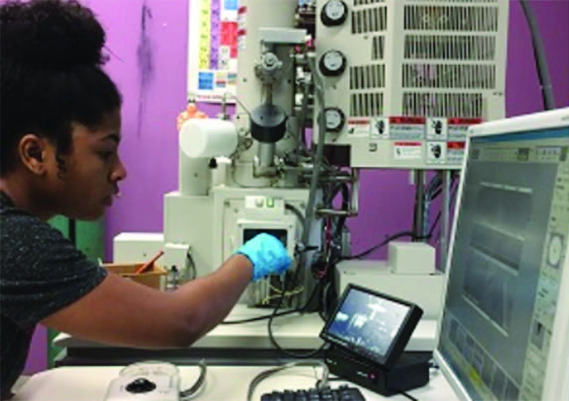 Jada Adams is loading a sample in a Hitachi S-4800 FESEM with the help of a camera